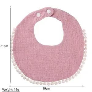 Pink cotton muslin baby bib with pom-pom trim and adjustable snaps 21x19cm