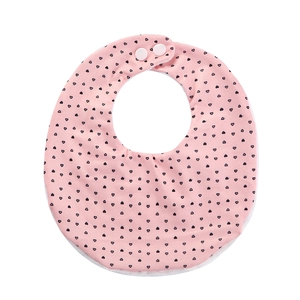 Close-up of pink baby bib with heart print, soft cotton fabric and snap fasteners