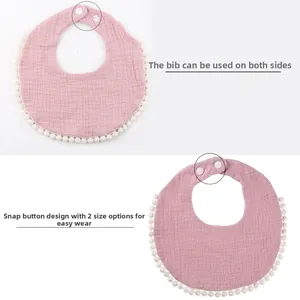 Cotton gauze baby bib with adjustable plastic snaps and decorative white pompom trim