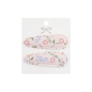 Close-up of floral fabric hair clips with wave edges on a display card for kids