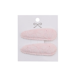 Close-up of pink lace floral embroidery hair clips on a premium white display card