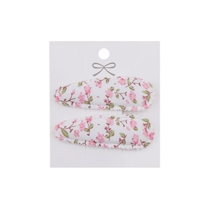 Detail of pink floral embroidery fabric hair clips on a white presentation card