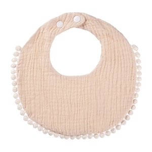 Detail of soft cotton gauze baby bib with fringe trim and adjustable snap buttons