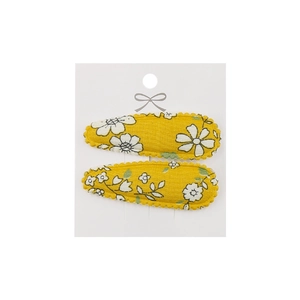 Detail of yellow floral embroidery fabric hair clips on a white presentation card