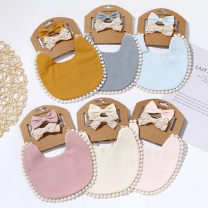 Boho baby bib and headband set with white pompom trim in diverse soft pastel colors