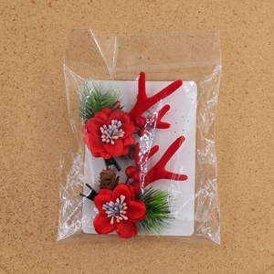 Detailansicht der Weihnachts-Rentier-Haarspangen mit Pinienzapfen und roten Blumen