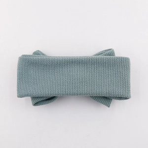 Détail du bandeau bébé en tricot côtelé bleu poudré avec un nœud doux et une texture fine