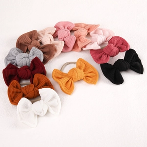 Detailed set of twelve colorful waffle knit bow headbands with elastic nylon for babies