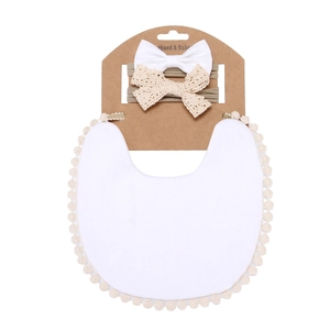 Detail of white cotton lace bib and two matching bow headbands on a kraft card