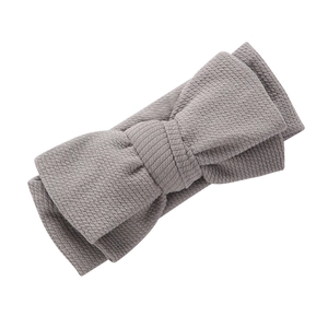 Détail du tissu en maille côtelée grise et du double nœud sur le bandeau pour bébé