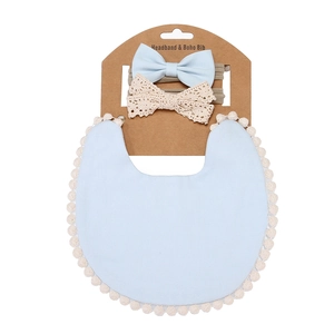 Close-up of baby headband and boho bib set on display card with soft blue fabric