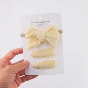 Three-piece handmade yellow fabric hair accessory set with bow headband and clips