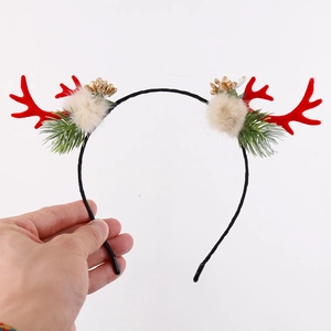 Close-up of Christmas deer antler headband with red antlers and decorative fur balls