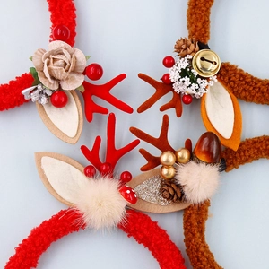 Detail of Christmas reindeer antler headband with bells, pine cones and red berries