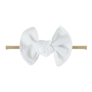 Detailed view of white waffle weave fabric bow and soft nylon baby headband strap