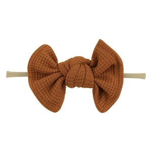 Detailed view of the waffle fabric texture on a brown baby bow headband for infants