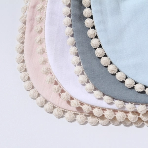 Soft bamboo cotton baby bibs with pom-pom trim in pink, white, grey, and blue colors