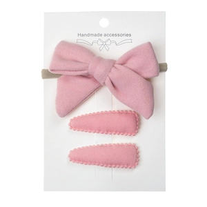 Close-up of pink bow headband and clip set on a handmade display card