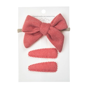 Detailed view of handmade coral pink fabric bow and drop-shaped hair clips for kids