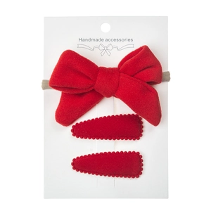Detailed view of red velvet bow headband and teardrop clips set on a handmade card