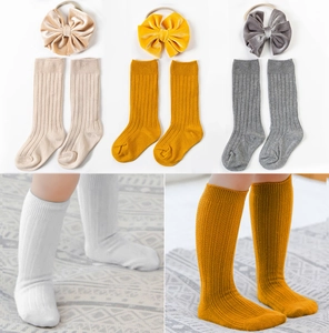 Detailed knit texture of baby socks and velvet bow headbands in soft autumn colors