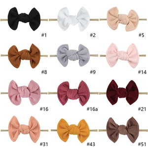 Set of 12 waffle fabric bow baby headbands in various colors on high-stretch nylon bands