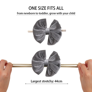 Elastic gray velvet bow headband for infants showing stretchable fabric and soft texture
