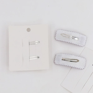 Close-up of wavy faux cashmere BB hair clips with silver metal backing and white card packaging