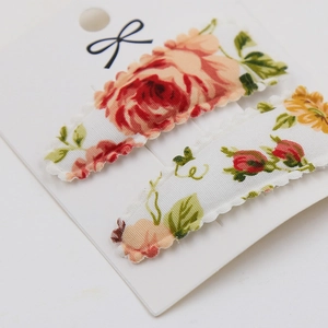 Detail view of vintage floral fabric hair clips in a set of two on display card