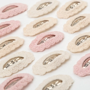 Pink and beige hand-knitted cotton lace BB hair clips in a minimalist array style