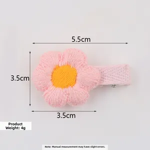 Detail view of pink hand-knit floral hair clip with 5.5cm dimensions and yellow center