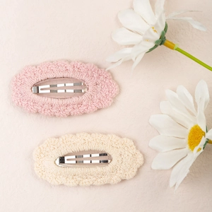 Pair of handmade knit cotton hair clips in pink and beige with scalloped lace design