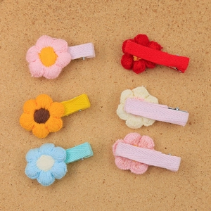 6-piece set of handmade knitted flower hair clips for girls on cork background
