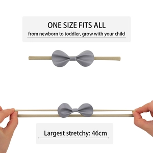Detail of high-elasticity baby headband showing a grey PU leather bow being stretched