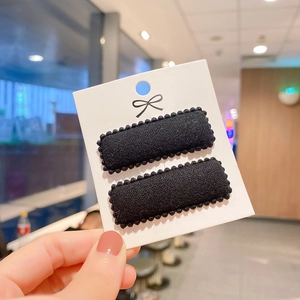 Detail of black faux cashmere square BB hair clips with pom-pom lace edge on display card
