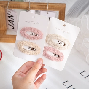 Close-up of handmade crochet cotton snap clip set in pink and beige tones