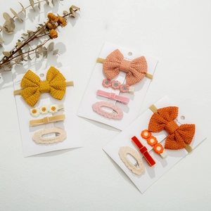 Detail of 4-piece kids hair accessory set with knitted bow headband and cute floral clips
