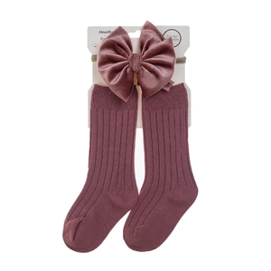 Detail of rose pink baby socks and velvet bow headband set for infants 0-24 months