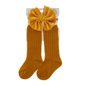 Detail of ginger yellow ribbed baby socks set with velvet bow headband for autumn winter