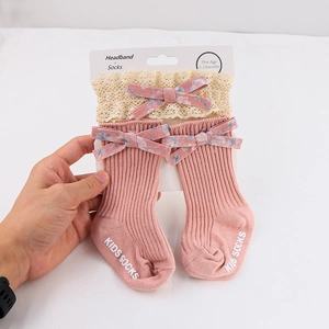 Detail of baby pink knit socks and lace headband set for infants aged 0-12 months