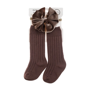 Close-up of baby headband with velvet bow and matching ribbed cotton socks set