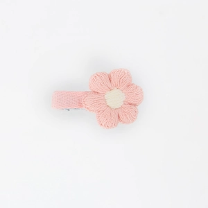 Detail view of handmade pink crocheted flower hair clip with soft woven cotton texture