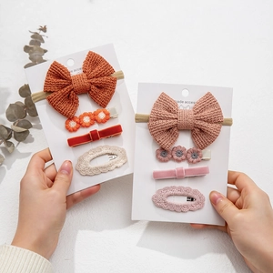 Detail of four-piece knit bow hair clips with velvet and lace texture on card