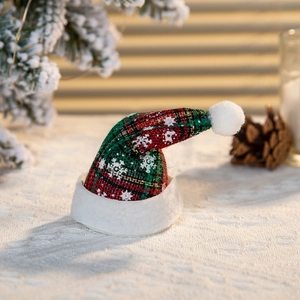 Dettaglio del mini cappello di Natale a quadri con fiocchi di neve e bordo in peluche bianco
