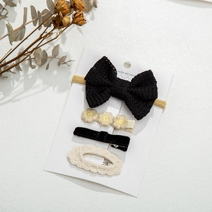 Detail view of 4-piece knit hair accessory set with bows and floral clips on display card