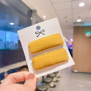 Detail of yellow wool fabric square hair clips with scalloped edges for girls