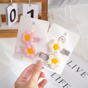 Handmade crochet flower hair clips in pink and cream white on a white display card