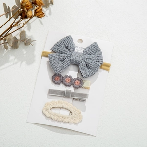 Detail view of 4-piece knit hair accessory set featuring bows and flowers on a display card