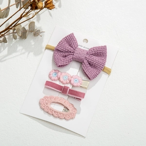 Detail of baby hair accessory set with pink bows and purple knitted headband