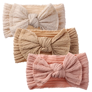 Detailed view of three baby headbands with knitted texture and decorative soft bows
